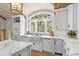 Modern kitchen boasts white cabinets, marble countertops, and farmhouse sink at 3601 Ocean Blvd. N, Myrtle Beach, SC 29577