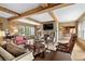 Spacious living room features exposed wooden beams, a stone fireplace, and ample natural light at 3601 Ocean Blvd. N, Myrtle Beach, SC 29577