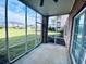 Screened porch overlooks a grassy area with community buildings in the distance at 4819 Orchid Way # 104, Myrtle Beach, SC 29577