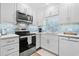 Bright white kitchen with stainless steel appliances and light blue tile backsplash at 5601 N Ocean Blvd. # D111, Myrtle Beach, SC 29572