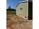 Side view of manufactured home showcasing its light green siding and brick foundation at 8750 W Highway 19, Loris, SC 29569