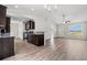 Open concept kitchen and living area with dark brown cabinets and luxury vinyl plank flooring at 326 Barn Owl Way, Conway, SC 29527