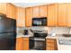 Well-equipped kitchen featuring ample wood cabinets, black appliances, and a modern cooktop at 4541 Girvan Dr. # 27-D, Myrtle Beach, SC 29579