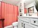Bathroom with coral shower curtain, gray vanity, and decorative accents at 230 Mint Ct., Little River, SC 29566