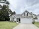 House exterior with gray siding, stone accents, and a two-car garage at 230 Mint Ct., Little River, SC 29566