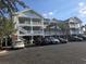 Three-story building exterior with parking lot at 5801 Oyster Catcher Dr. # 413, North Myrtle Beach, SC 29582