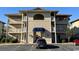 Tan three-story building with blue awning and parking lot at 4278 Pinehurst Circle # W2, Little River, SC 29566