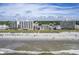 Aerial view of oceanfront property with beach, high-rise buildings, and lush greenery at 4105 S Ocean Blvd. S # 102, North Myrtle Beach, SC 29582