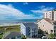 Oceanfront property view with beach access, featuring a light blue house and other buildings nearby at 4105 S Ocean Blvd. S # 102, North Myrtle Beach, SC 29582