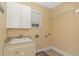 Convenient laundry room with upper cabinets, a utility sink and shelving at 676 Oxbow Dr., Myrtle Beach, SC 29579