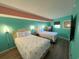 Bedroom with two twin beds, flamingo bedding, and teal walls at 7100 Ocean Blvd. N # 919, Myrtle Beach, SC 29572