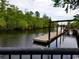 Floating dock on calm river with lush greenery at 332 Kiskadee Loop # L, Conway, SC 29526
