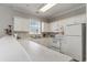 Bright kitchen featuring white cabinets, appliances, and a breakfast bar at 332 Kiskadee Loop # L, Conway, SC 29526