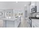 Modern kitchen with island, white cabinets and stainless steel appliances at 8605 Pinnacle Cove Way, Longs, SC 29568