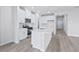 Modern kitchen with island, white cabinets, and stainless steel appliances at 8605 Pinnacle Cove Way, Longs, SC 29568