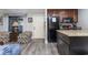 Open kitchen with granite countertops, dark wood cabinets, and black appliances at 118 Salt Marsh Circle # 25-I, Pawleys Island, SC 29585