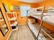 Bunk beds in a bright bedroom with orange walls and wood-look flooring at 6001 - M26 S Kings Hwy., Myrtle Beach, SC 29575