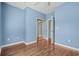 Light blue bedroom with wood floors and mirrored closet doors at 336 Kiskadee Loop # B, Conway, SC 29526