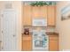 White appliances and light wood cabinets in this galley kitchen at 5804 Longwood Dr. # 203, Murrells Inlet, SC 29576