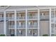 Three-story building with light beige siding and white columns at 5804 Longwood Dr. # 203, Murrells Inlet, SC 29576