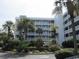 Attractive building exterior with landscaping and palm trees at 9580 Shore Dr. # 303, Myrtle Beach, SC 29572