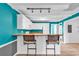 White kitchen cabinets, teal walls, breakfast bar with two stools at 519 31St Ave. N # 7, Myrtle Beach, SC 29577