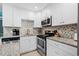 Modern kitchen featuring white cabinets, granite counters, and stainless steel appliances at 5601 N Ocean Blvd. # C-202, Myrtle Beach, SC 29577