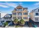 Beautiful beach house exterior; three stories, light yellow with dark roof at 132 N Waccamaw Dr., Murrells Inlet, SC 29576