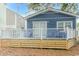 Elevated deck with white railings, blue chairs, and a view of a blue house at 6001-1157 S Kings Hwy., Myrtle Beach, SC 29575