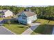 Aerial view of a two-story light blue house with a side yard and driveway at 1315 Bermuda Grass Dr., Myrtle Beach, SC 29579