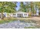 White cottage with black shutters, a front yard and mature trees at 615 1St Ave. N, Surfside Beach, SC 29575