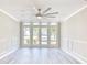 Spacious living room featuring vinyl plank floors, a ceiling fan and French doors at 615 1St Ave. N, Surfside Beach, SC 29575
