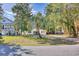 White cottage nestled amongst lush greenery, showcasing curb appeal at 615 1St Ave. N, Surfside Beach, SC 29575