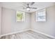 Well-lit bedroom with ceiling fan, wood-look flooring, and two windows at 615 1St Ave. N, Surfside Beach, SC 29575
