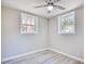 Bright bedroom with ceiling fan, wood-look flooring, and two windows at 615 1St Ave. N, Surfside Beach, SC 29575