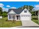 House exterior featuring gray siding, white accents, and a two-car garage at 508 Shellbark Dr., Longs, SC 29568