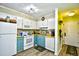 Small kitchen with teal cabinets and white appliances at 4305 S Ocean Blvd. # 205, North Myrtle Beach, SC 29582