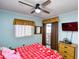 Bedroom with a red snowflake comforter, ceiling fan, and balcony access at 4305 S Ocean Blvd. # 205, North Myrtle Beach, SC 29582