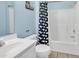 Clean bathroom with shower/tub combo, white vanity, and whale-themed shower curtain at 912-B S Ocean Blvd., Surfside Beach, SC 29575