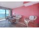 Living room with wicker furniture, ocean view, and pink walls at 1501 S Ocean Blvd. # 1038, Myrtle Beach, SC 29577