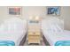 Two twin beds with white linens and a nightstand at 1207 S Ocean Blvd. # 20703, Myrtle Beach, SC 29577