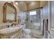 Bathroom with marble vanity, frameless shower, and ornate mirror at 9900 Bellasera Circle, Myrtle Beach, SC 29579