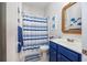 Charming bathroom with blue vanity, striped shower curtain, and nautical decor at 1426 Peterson St., Myrtle Beach, SC 29577