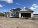 Newly constructed home with gray vinyl siding, a black roof and a two-car garage at 487 Highway 348, Loris, SC 29569