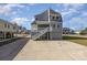 Two-story home with gray siding, elevated design, and a large backyard at 206 56Th Ave. N, North Myrtle Beach, SC 29582
