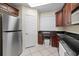 Modern kitchen with stainless steel refrigerator, dark wood cabinets, and granite countertops at 2709 Ocean Blvd. S # 1202, Myrtle Beach, SC 29577