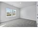 Well-lit bedroom with grey carpet and two windows at 680 Blackthorne Circle Nw, Calabash, NC 28467