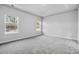 Bright bedroom with gray carpet, neutral walls, and two large windows at 680 Blackthorne Circle Nw, Calabash, NC 28467
