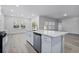 Kitchen island with white cabinets, quartz countertops, and a built-in sink at 680 Blackthorne Circle Nw, Calabash, NC 28467