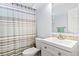 Clean bathroom with white vanity, striped shower curtain, and mosaic tile accents at 481 Irees Way, Longs, SC 29568